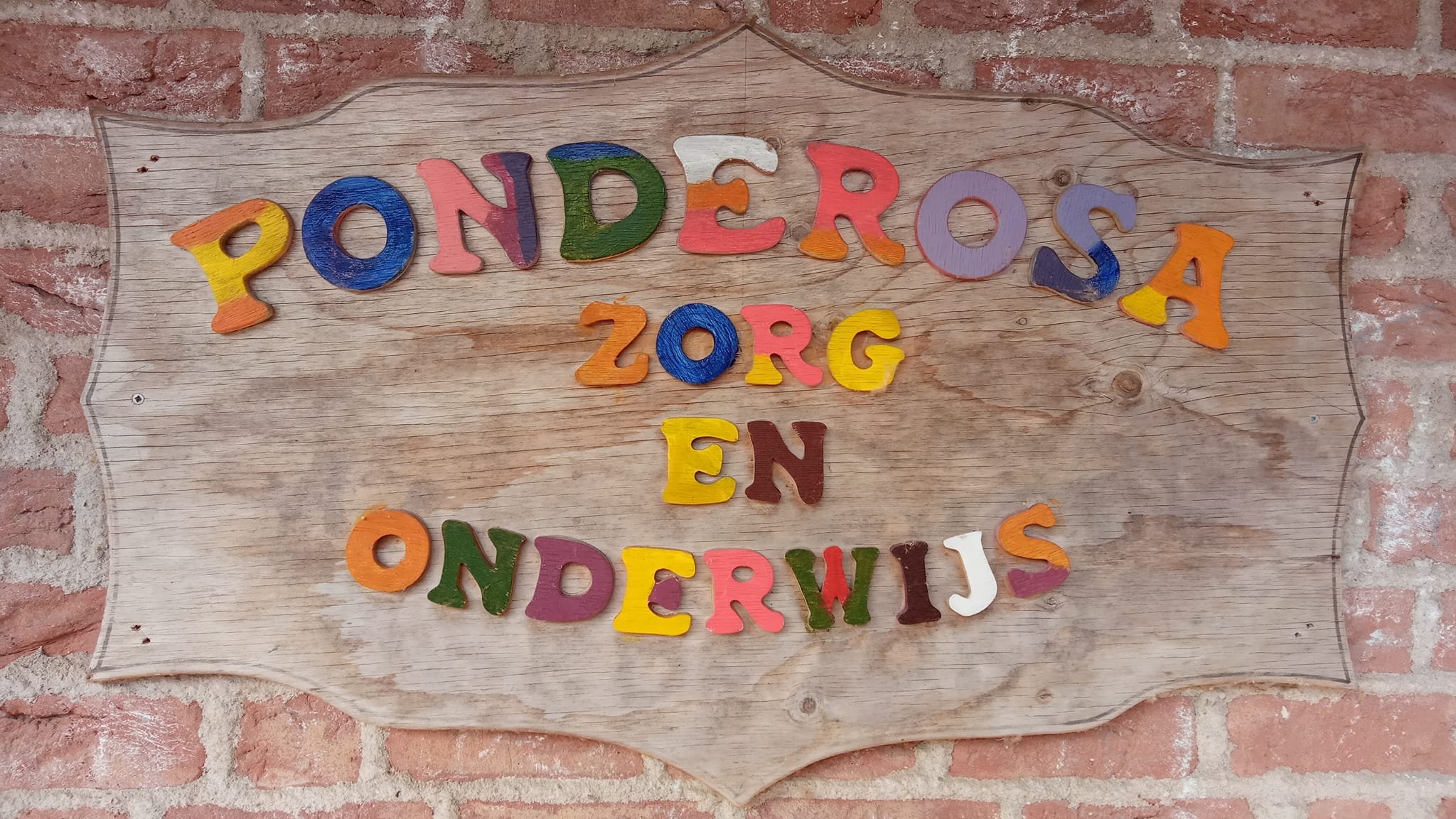 Het houten bord van de Ponderosa met de tekst Ponderosa, zorg en onderwijs
