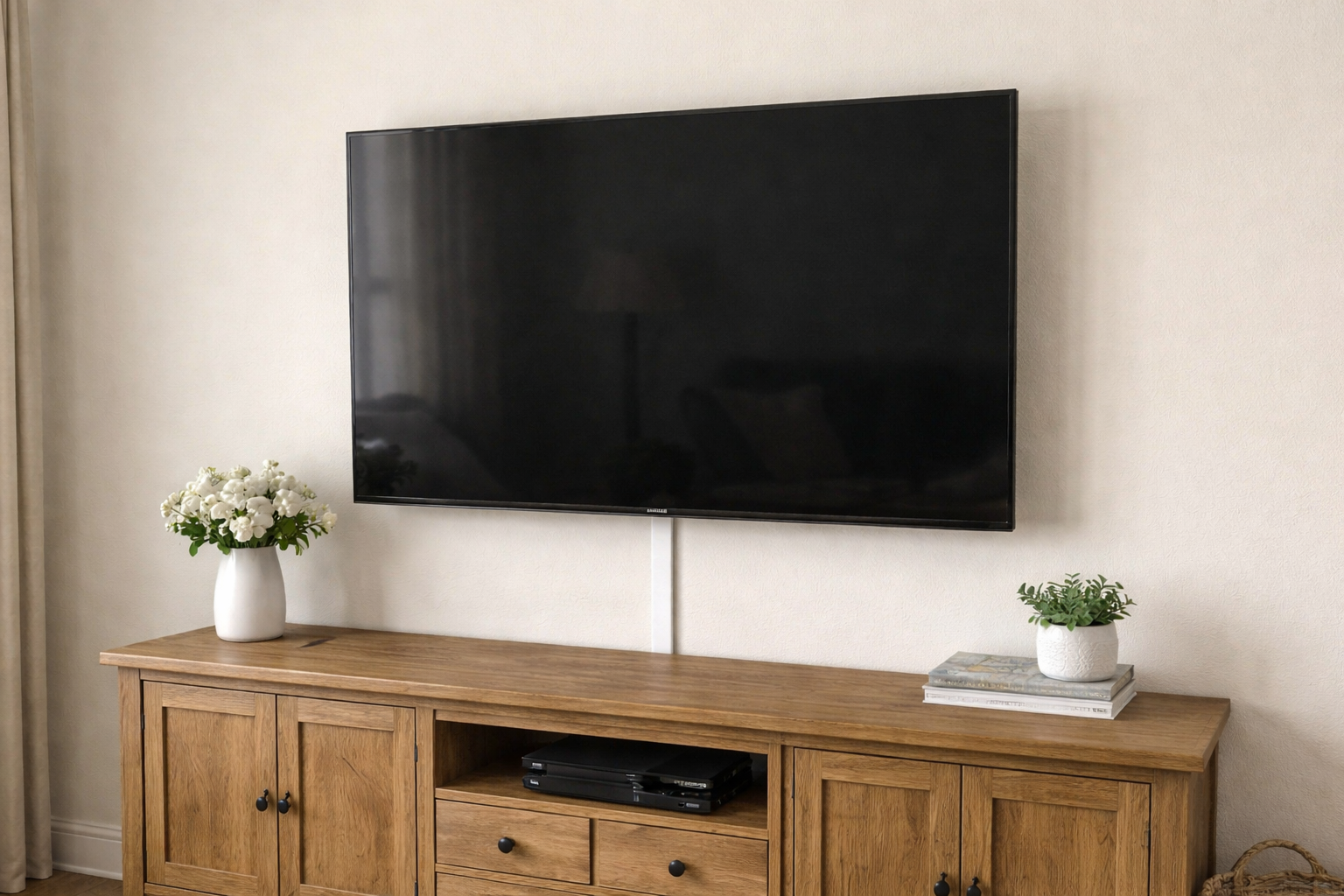 TV mounted with cables covered by a paintable cord channel on the wall