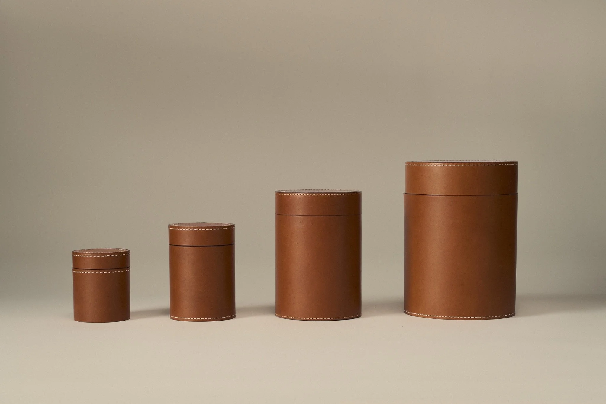 Four cognac RQVM urn sizes side by side, from Mini Keepsake to Large