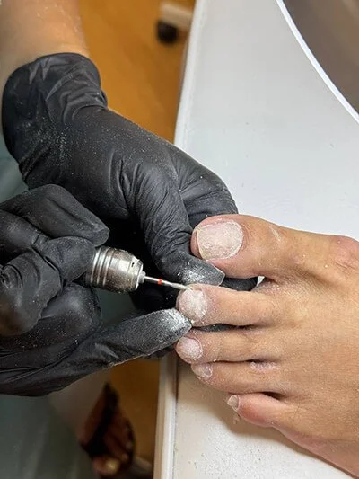 Close-up E-file toe preparation during a dry pedicure course in NYC