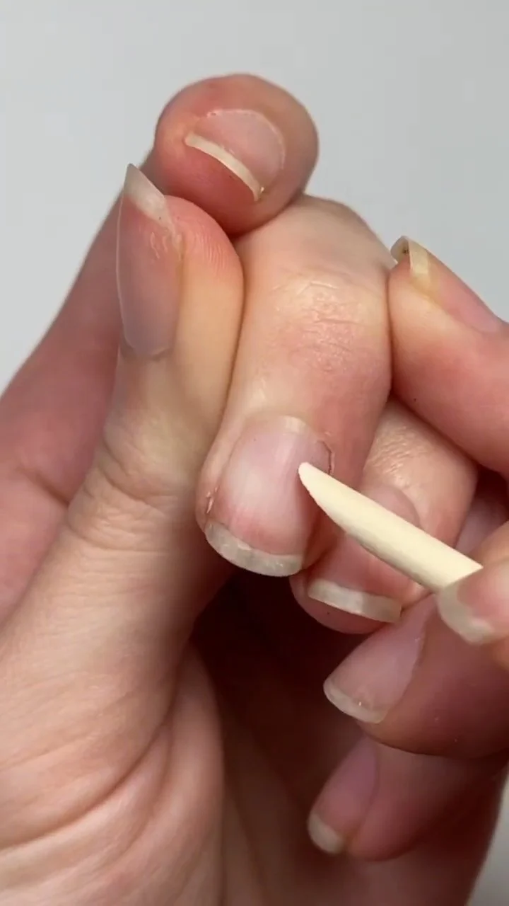 Pushing back the cuticle with an orange wood stick