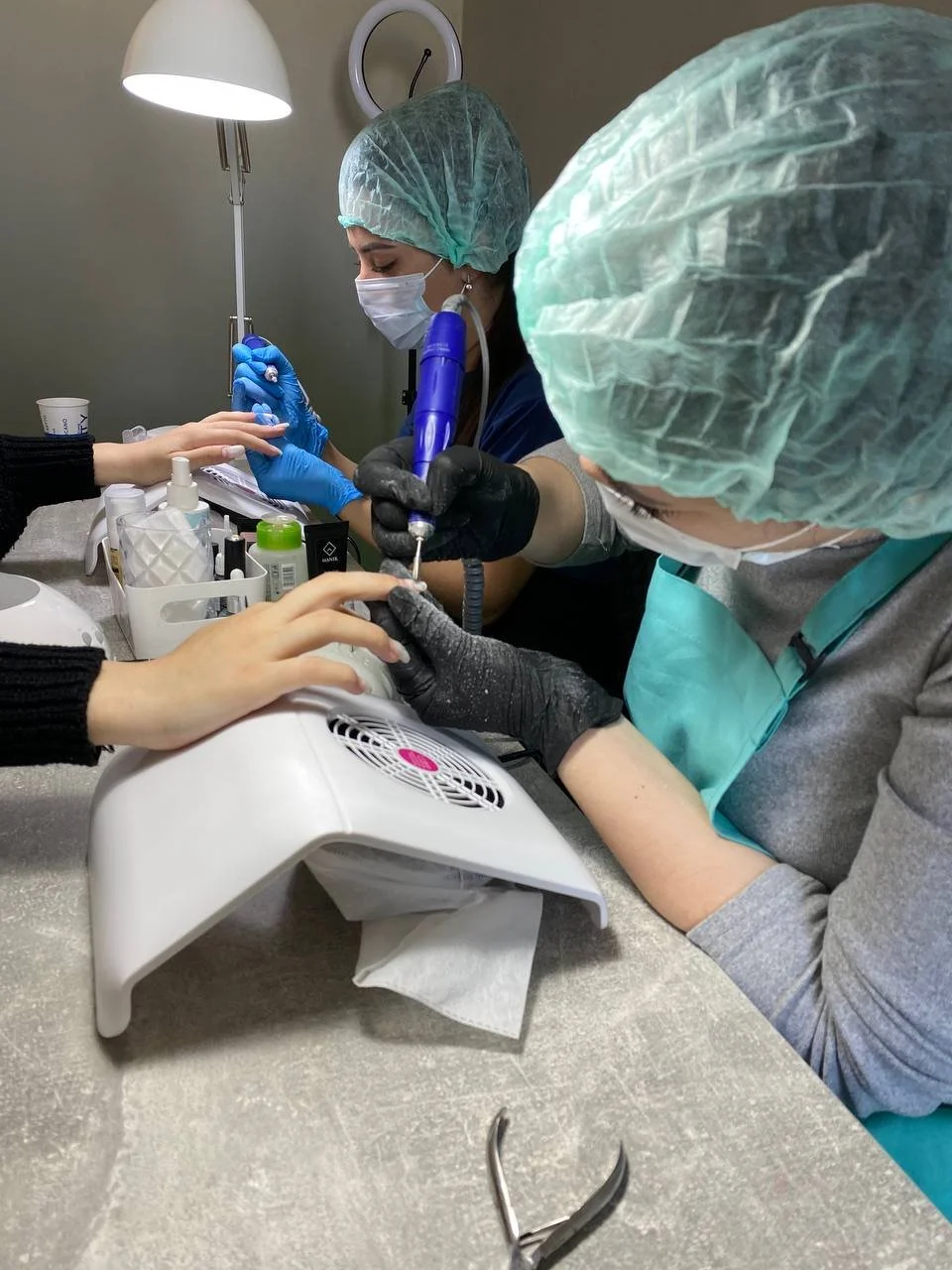 Instructor-guided Russian manicure training on live models at Mars Nails School in NYC