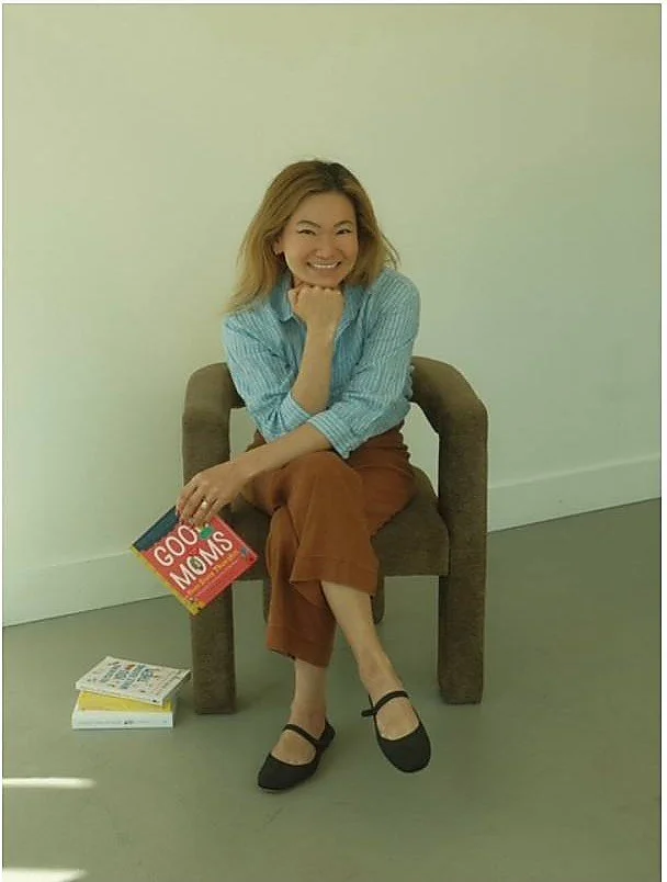 Susan Ko holding the book Good Moms