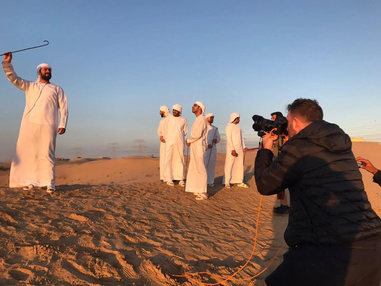Photographer working with a group of men in the desert during the Etisalat campaign.