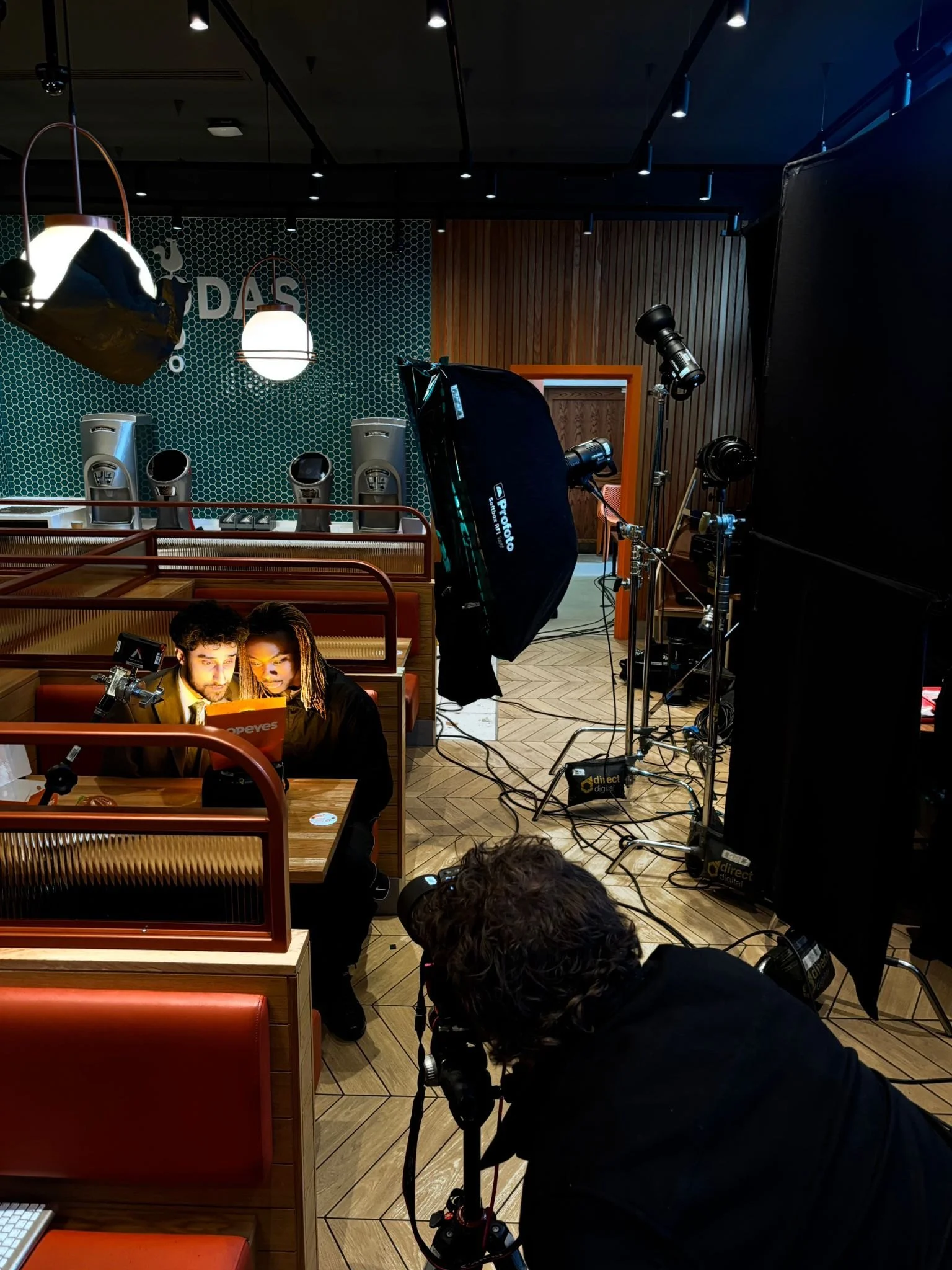 The Popeyes restaurant photography setup with external lights, crew and equipment behind the scenes.