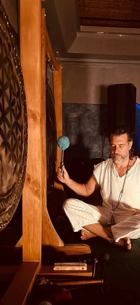 Lotus seated beside a gong with a mallet