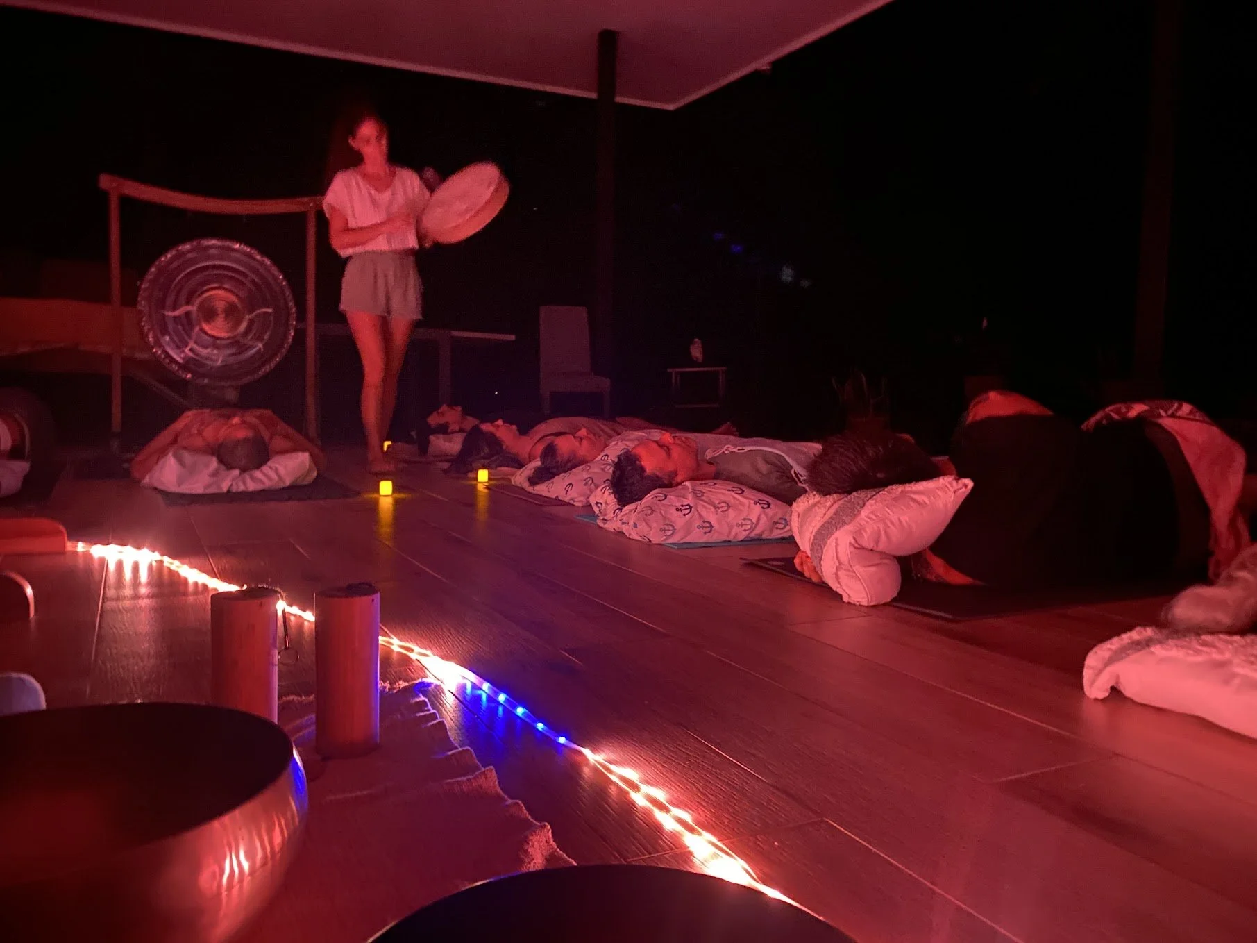 Yoselyn toca un tambor de marco durante un viaje sonoro grupal al anochecer