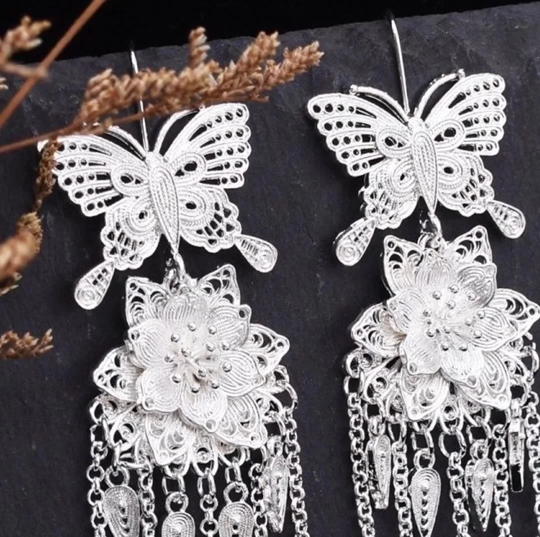 Filigree silver earrings with a butterfly, a blossom and hanging tassels