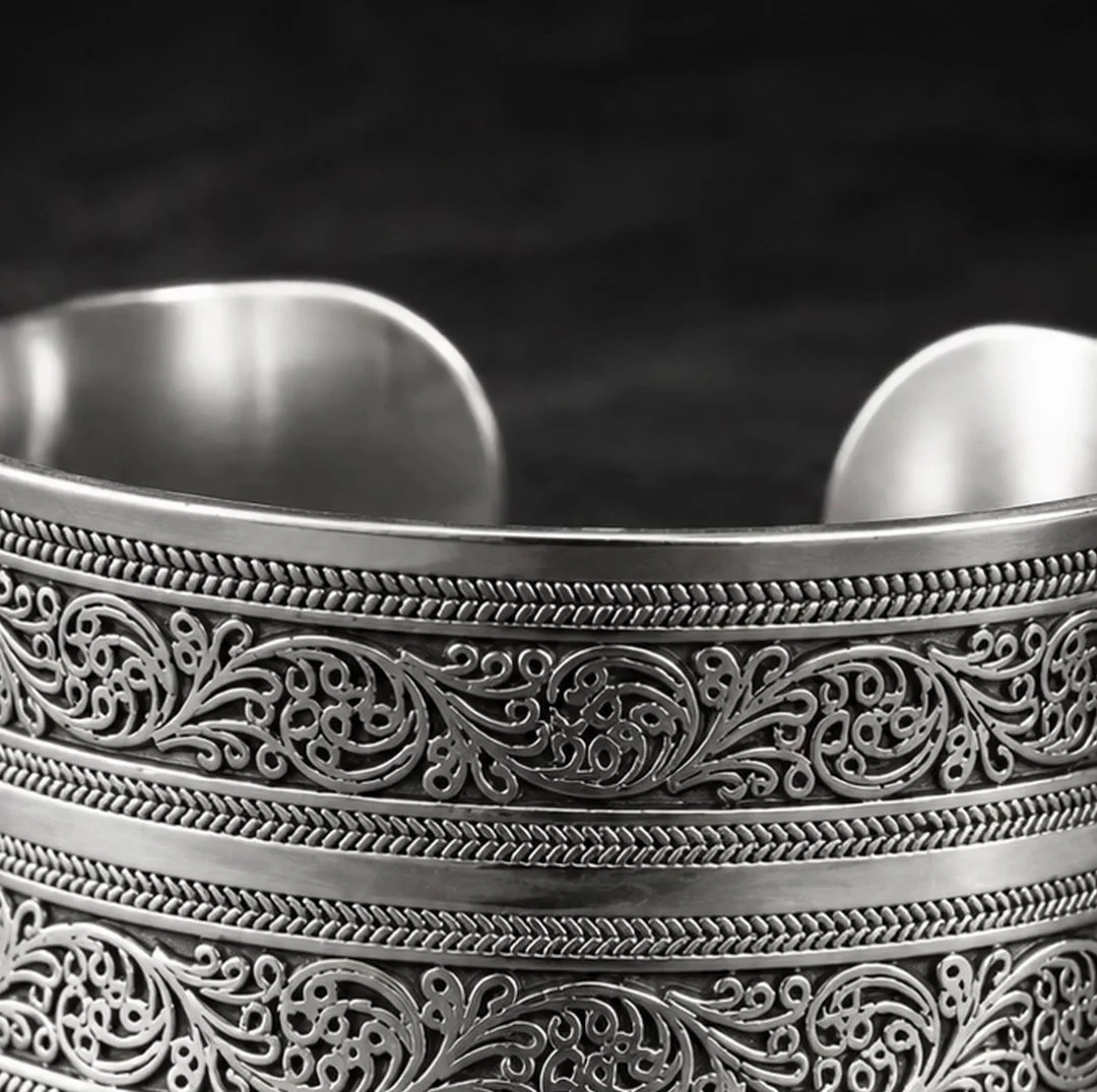A wide silver cuff with chased scrollwork bands