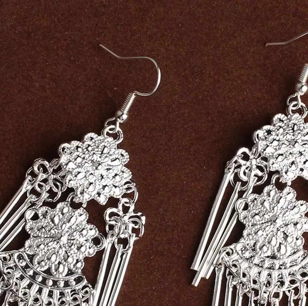 A pair of openwork floral silver earrings with long tube fringes