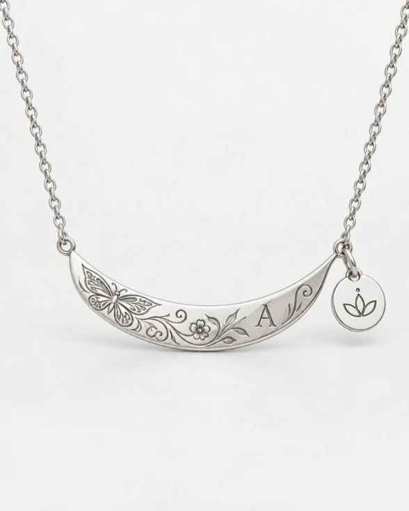 Mock-up: a hand-chased silver crescent pendant engraved with a butterfly, flowers and an initial