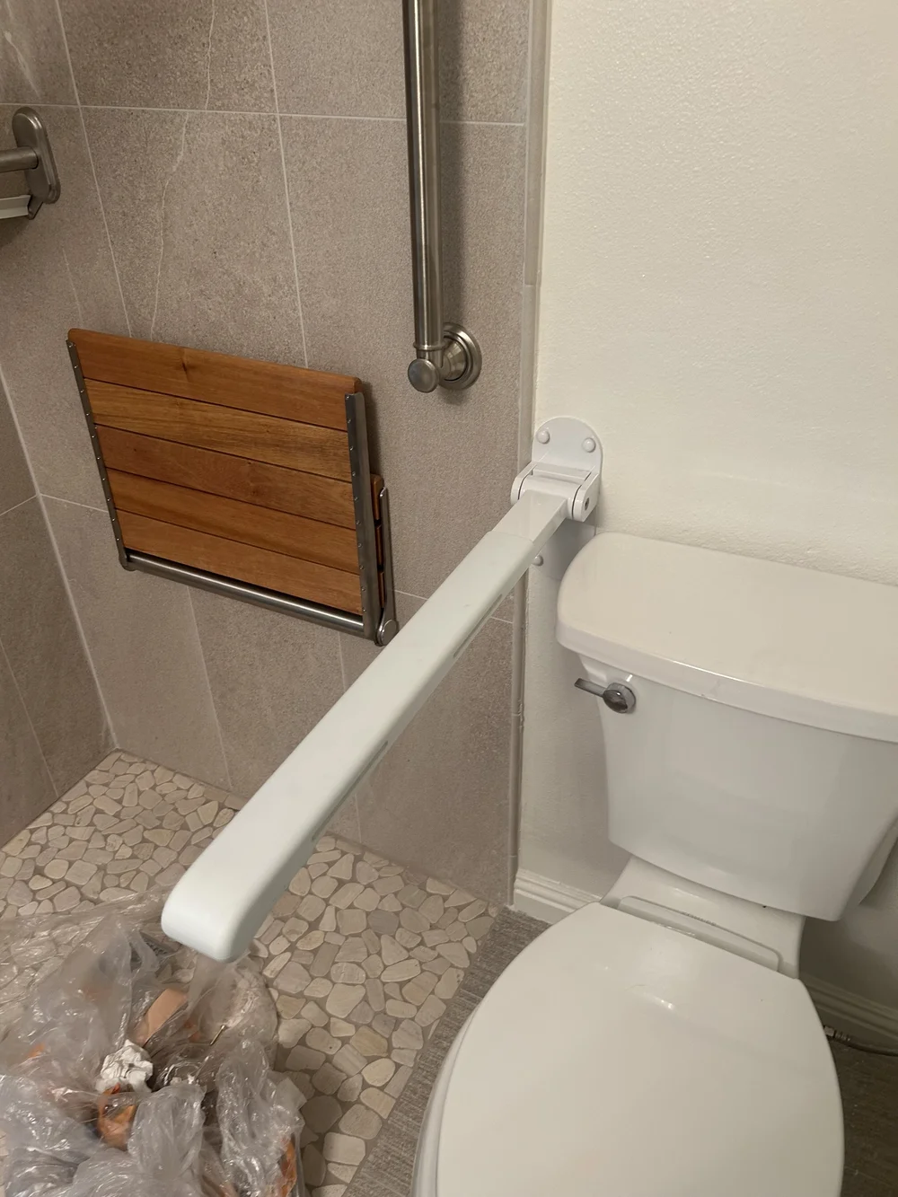 Fold-down support rail installed beside a toilet to support the standing transition
