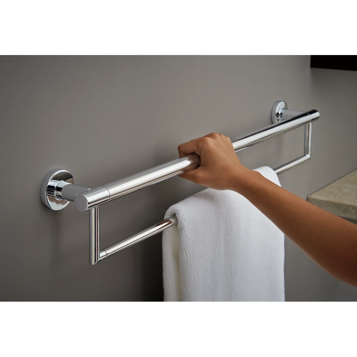 Designer grab bar in a polished finish that reads as a towel bar in a finished bathroom
