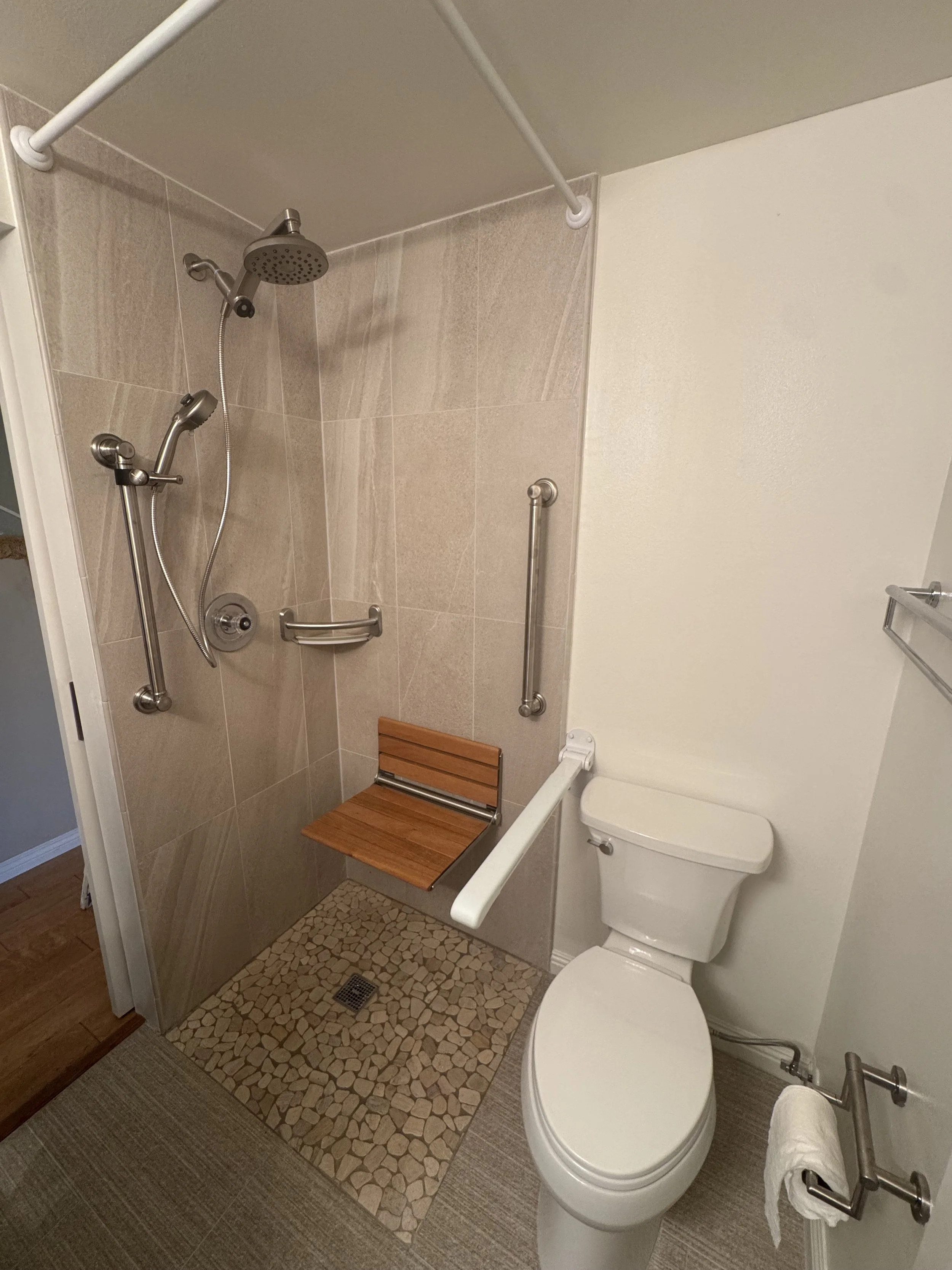 Accessible walk-in shower with panel walls and safety grab bars