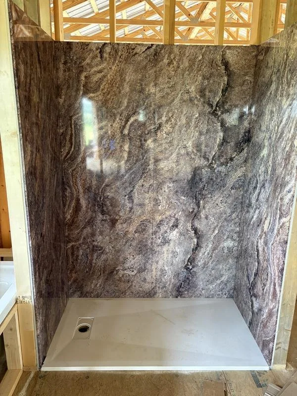 Dramatic stone-look panel walls taking shape in a walk-in shower conversion