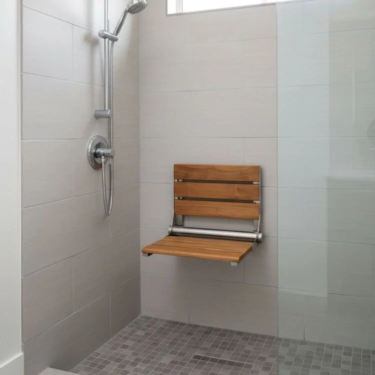 Fold-down shower seat mounted on a shower wall