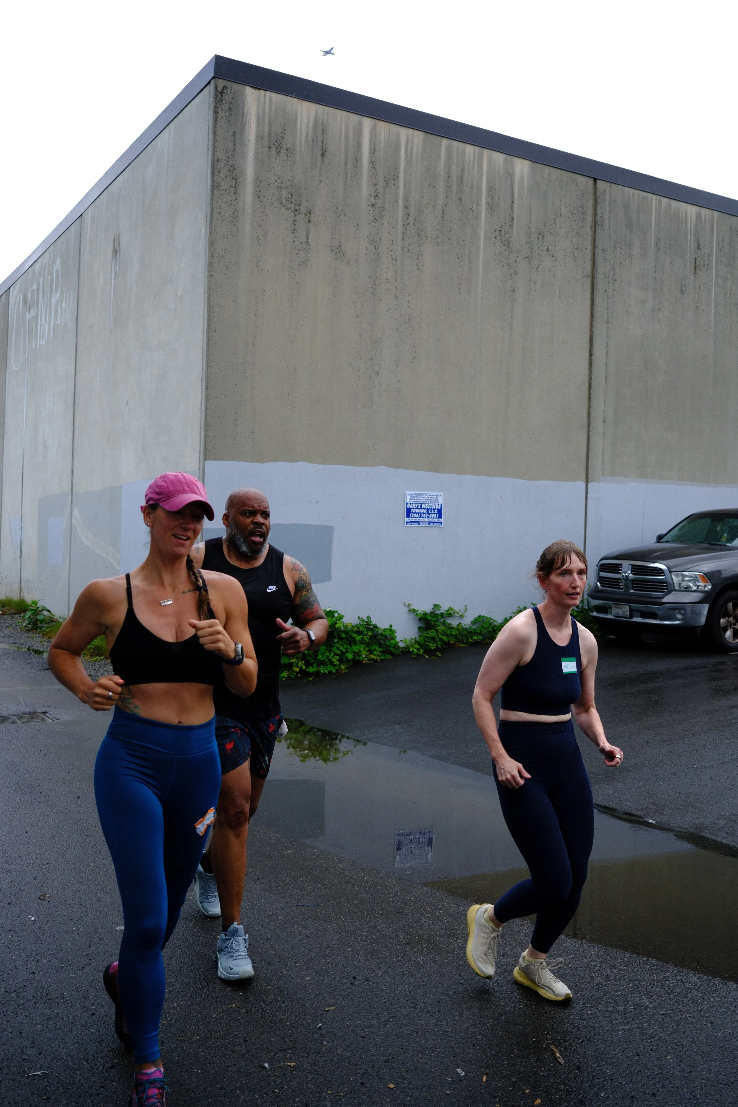 Members running the kilometer loop outside Root Strength in the Georgetown rain