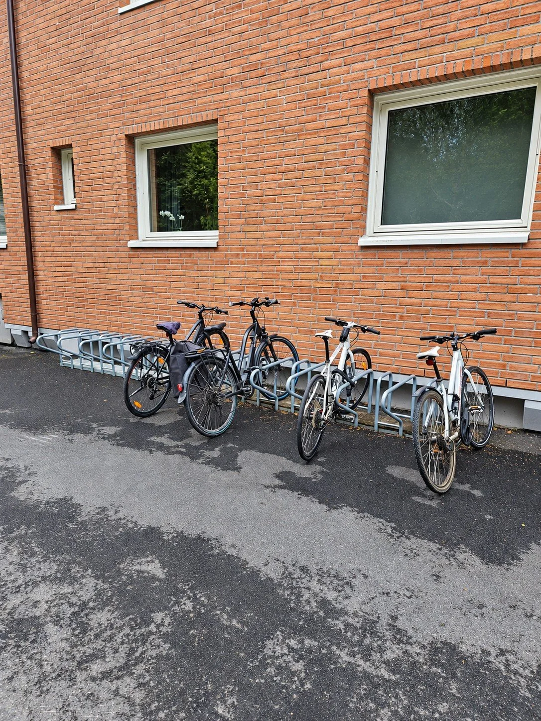SR Ensidig med parkerte sykler langs en teglfasade