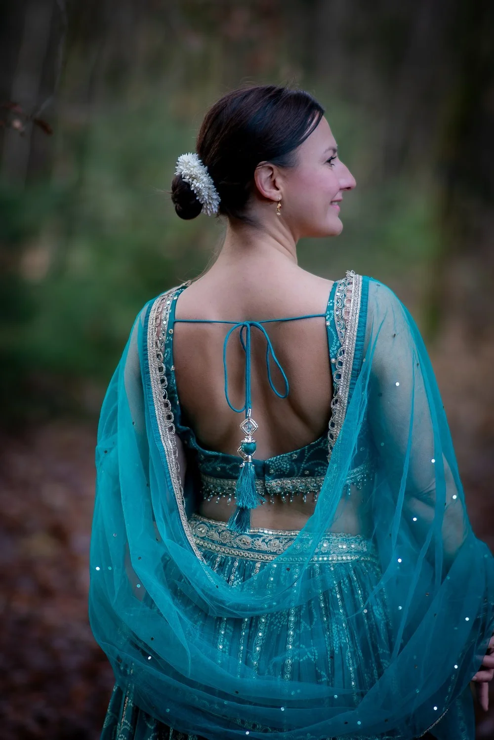 Frau im türkisfarbenen Kleid im Wald