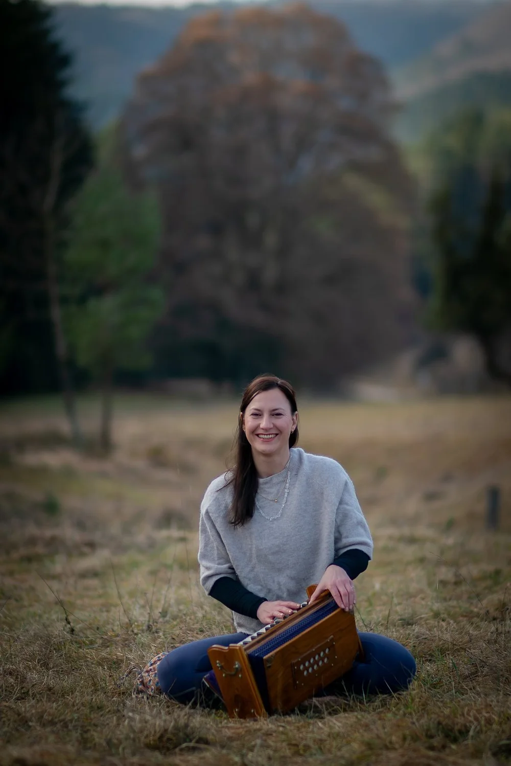 Frau mit Harmonium auf einer Wiese