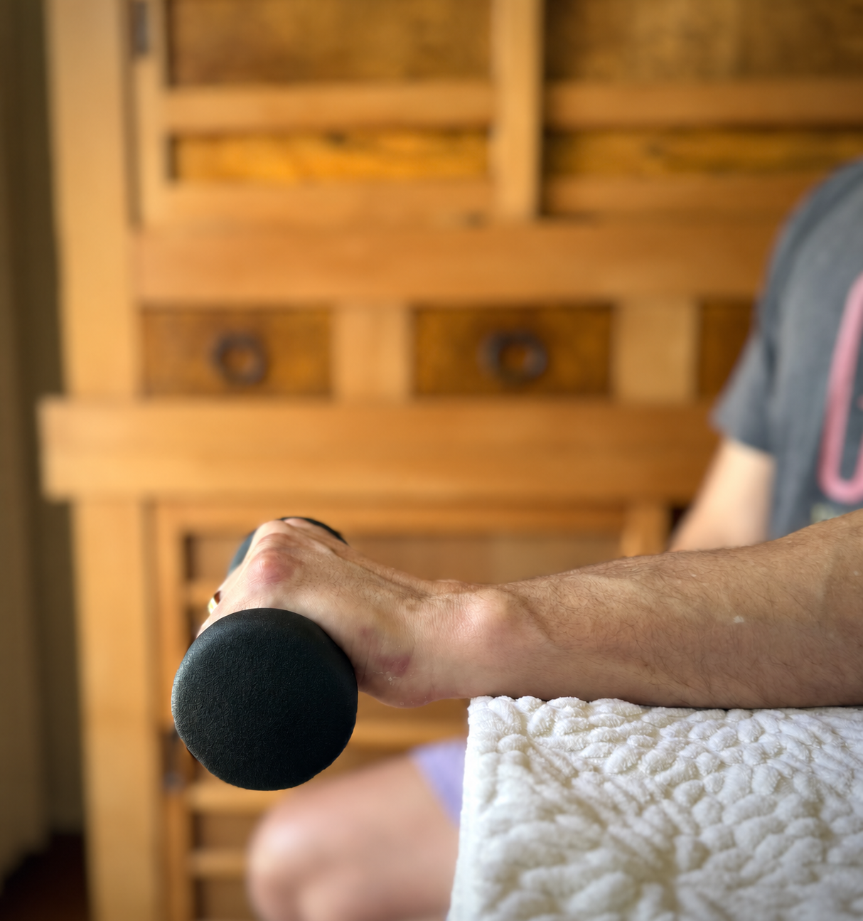 Hand holding a weight during a supported wrist exercise