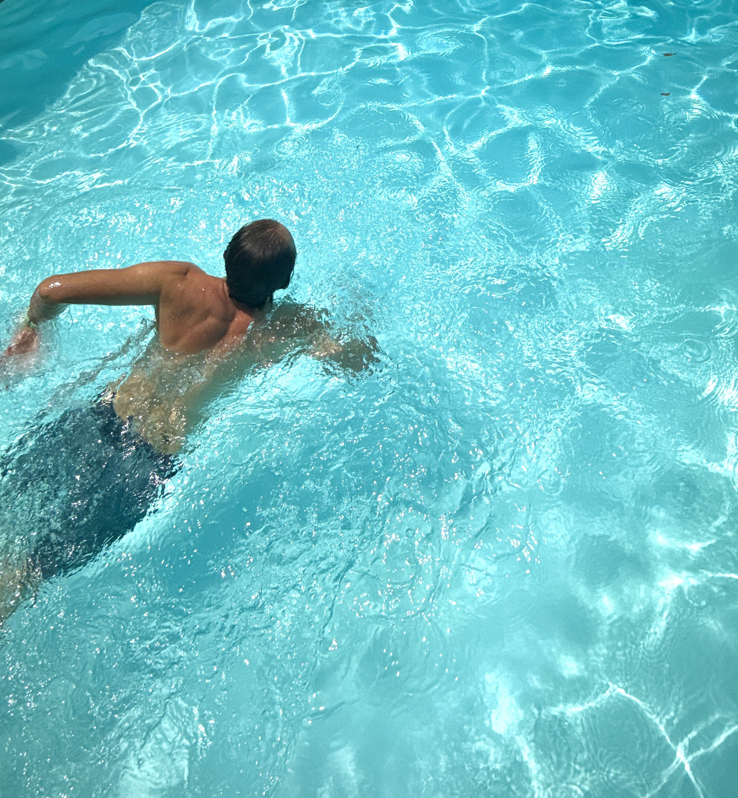 A swimmer moving through sunlit water
