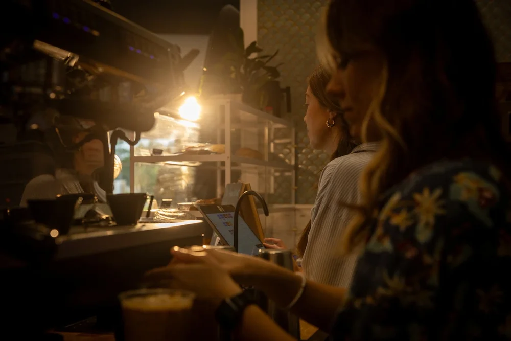 Baristas at the counter in golden light