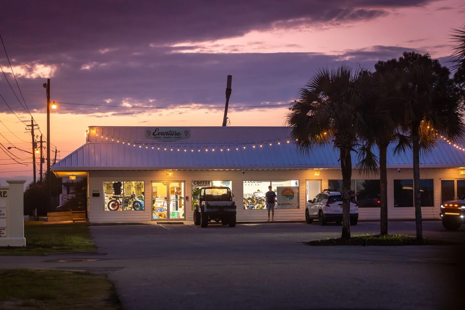 The Eventure and Waterborne storefront at sunset under string lights