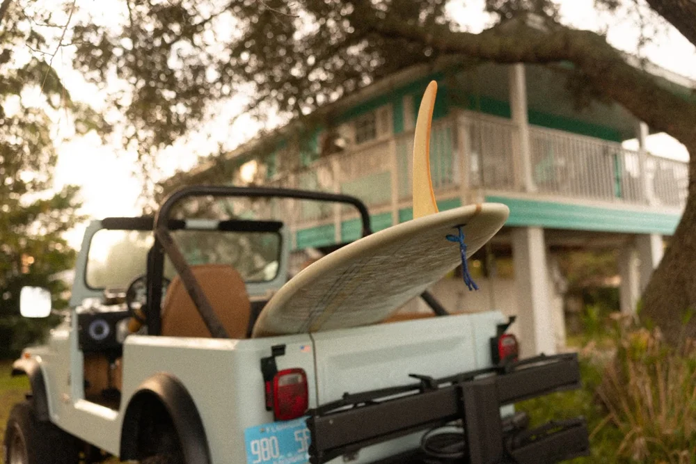 Longboard in the back of a vintage Jeep