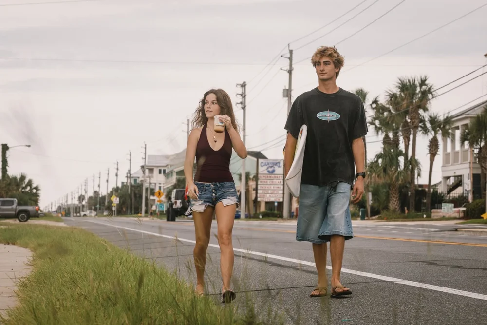 Two friends walking the Parkway with a Waterborne coffee and a surfboard