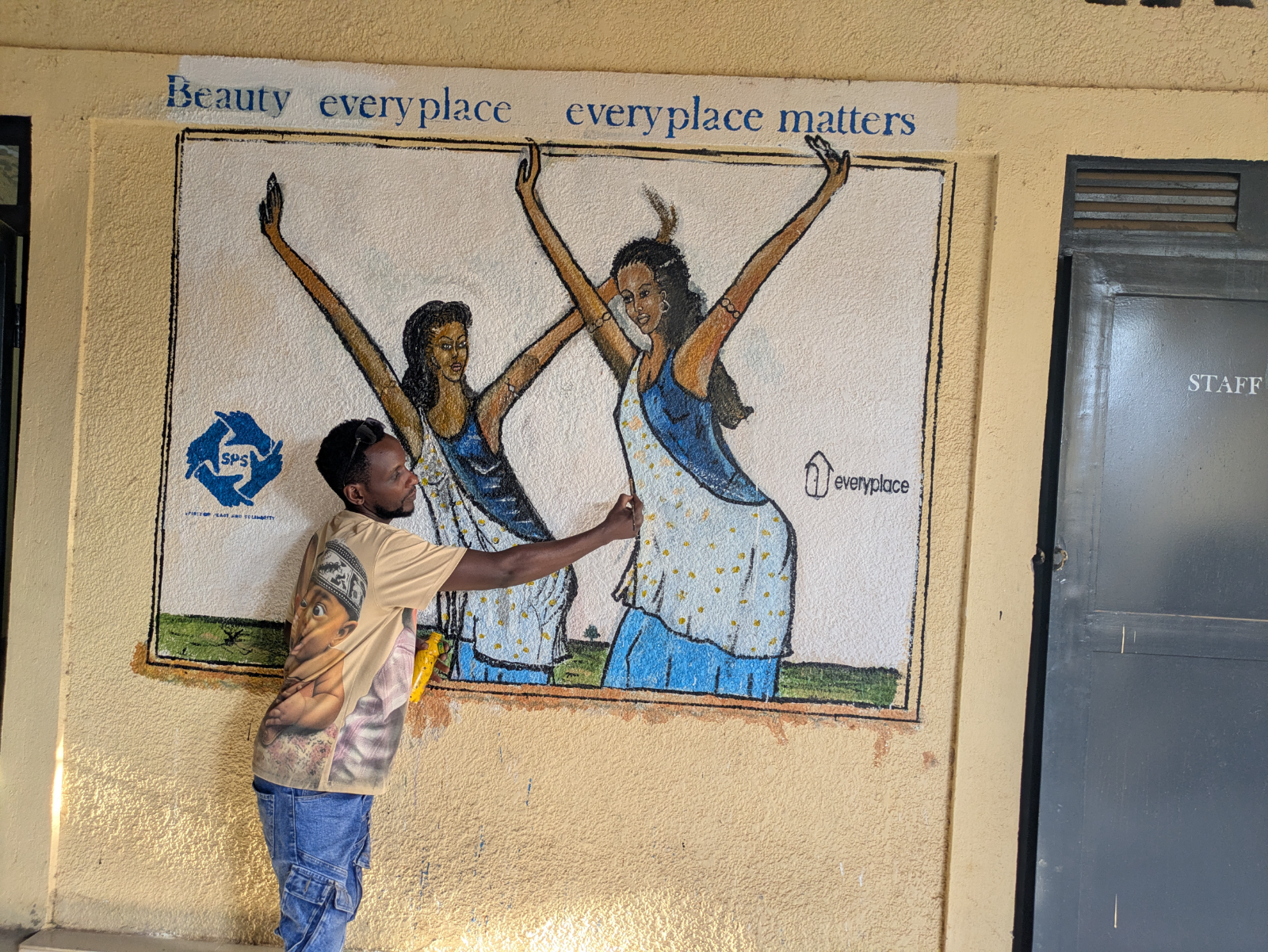 An artist painting the Everyplace and SPS mural in Rwanda