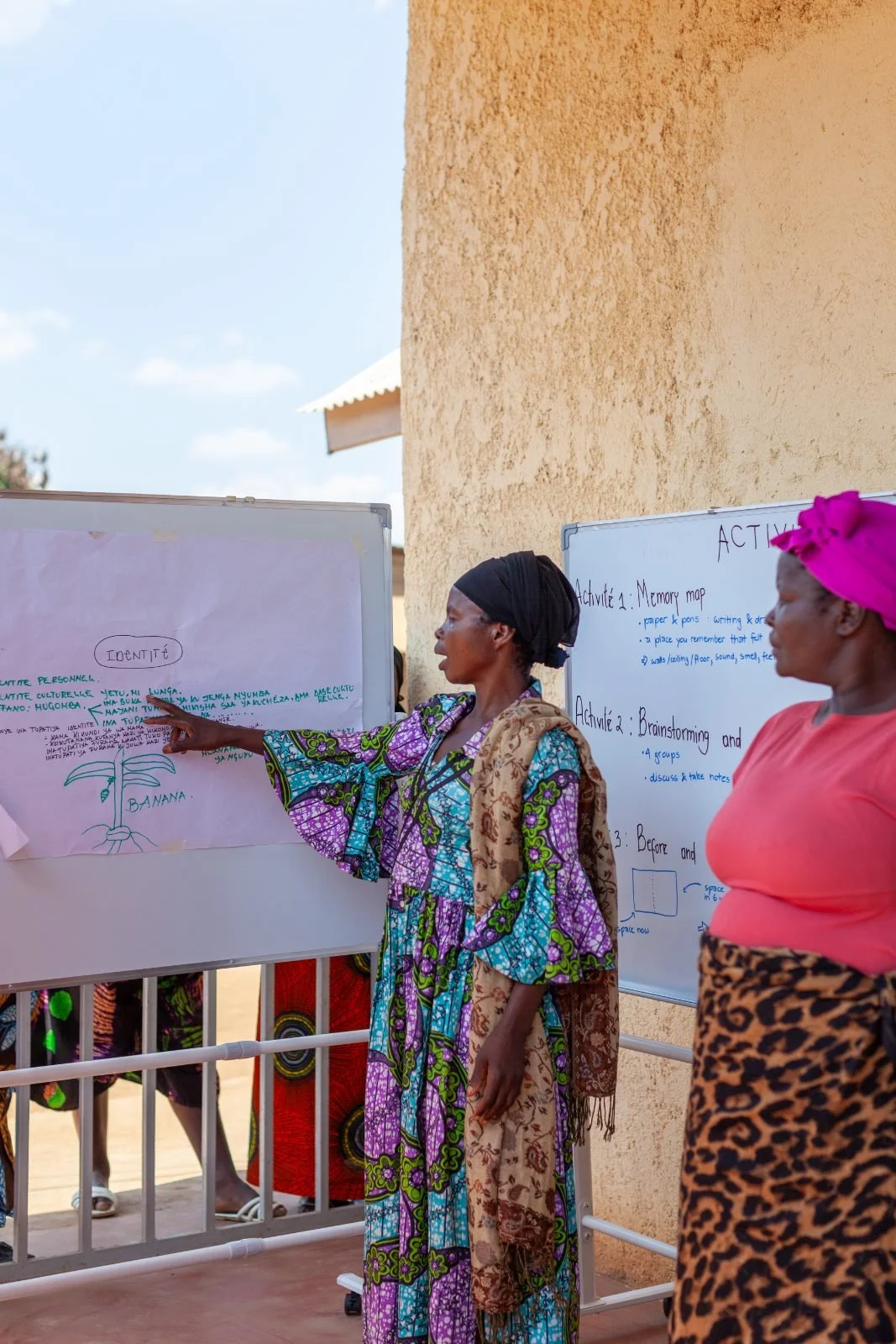A woman points to a community mapping sheet during a planning session