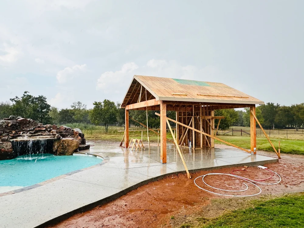 Munday pavilion framing and roof sheathing during construction beside the pool in Burleson