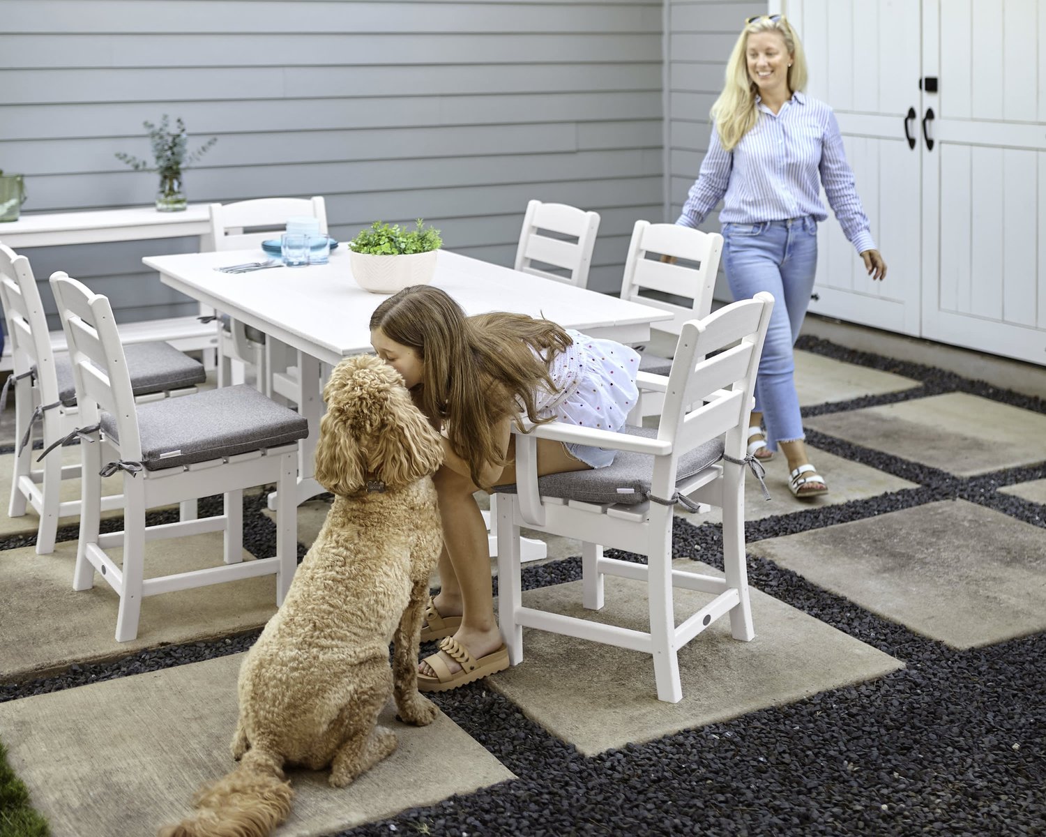 Family enjoying a white POLYWOOD outdoor dining set on a patio