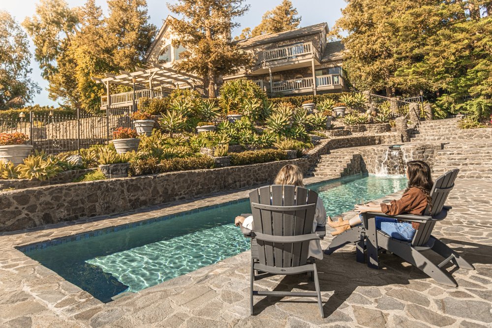 Guests relaxing in POLYWOOD lounge chairs beside a swimming pool