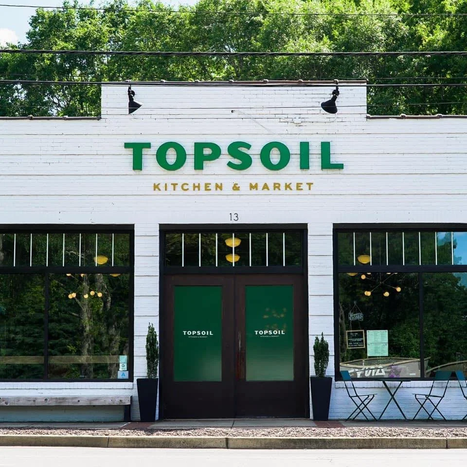 Farm-to-table dining featuring hyper-local ingredients at Topsoil Kitchen & Market, a James Beard semi-finalist gem near Riverdaze.