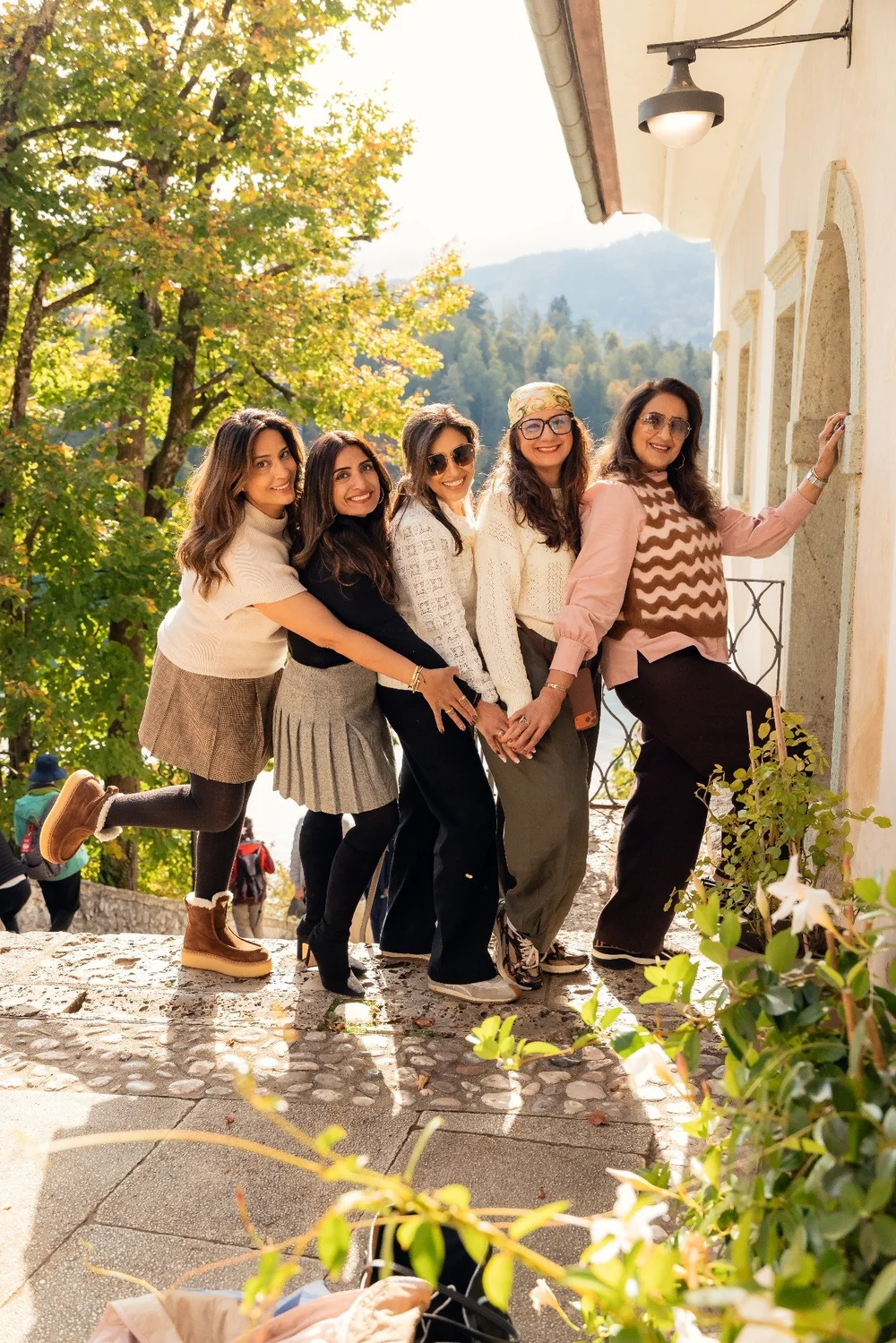 Five friends posing together on a terrace during their Bled portrait session.