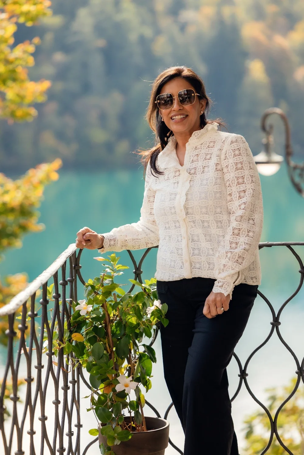 A smiling friend photographed beside a railing above Lake Bled.