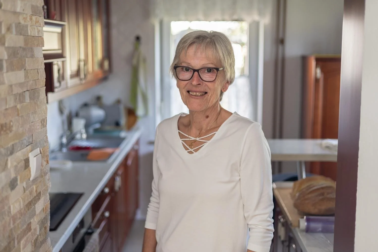 Francka Dolinar stands in a bright home kitchen.