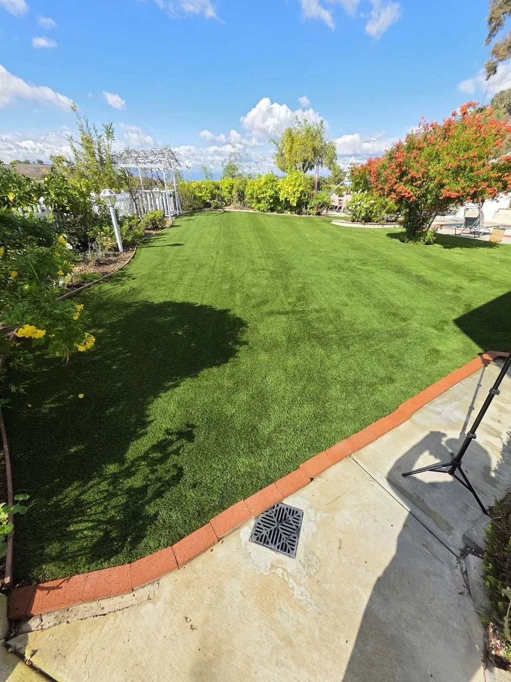 Large backyard artificial turf groomed into stripes after a Hydroforce cleaning