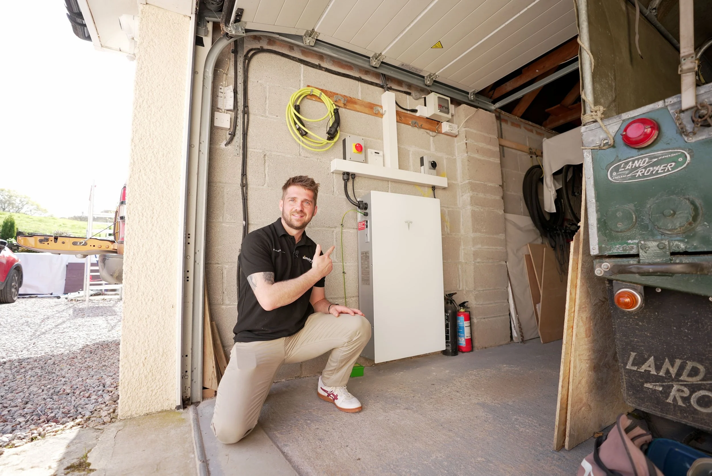 Home battery installed with inverter and electrical equipment in a garage.