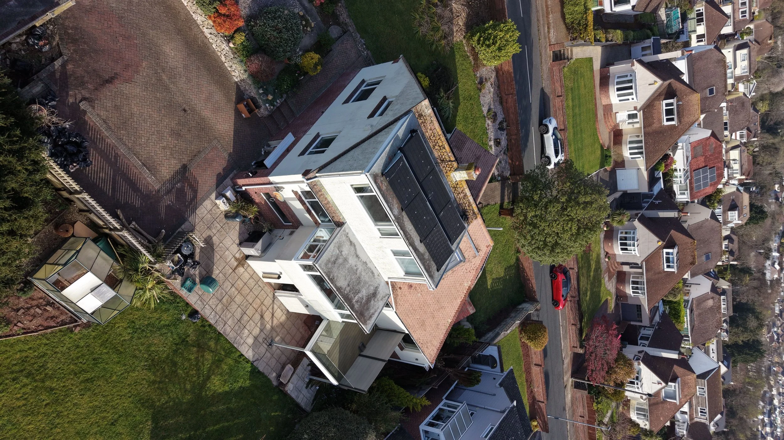 Residential Barnstaple property with solar panels on the roof and an air source heat pump installed at ground level.
