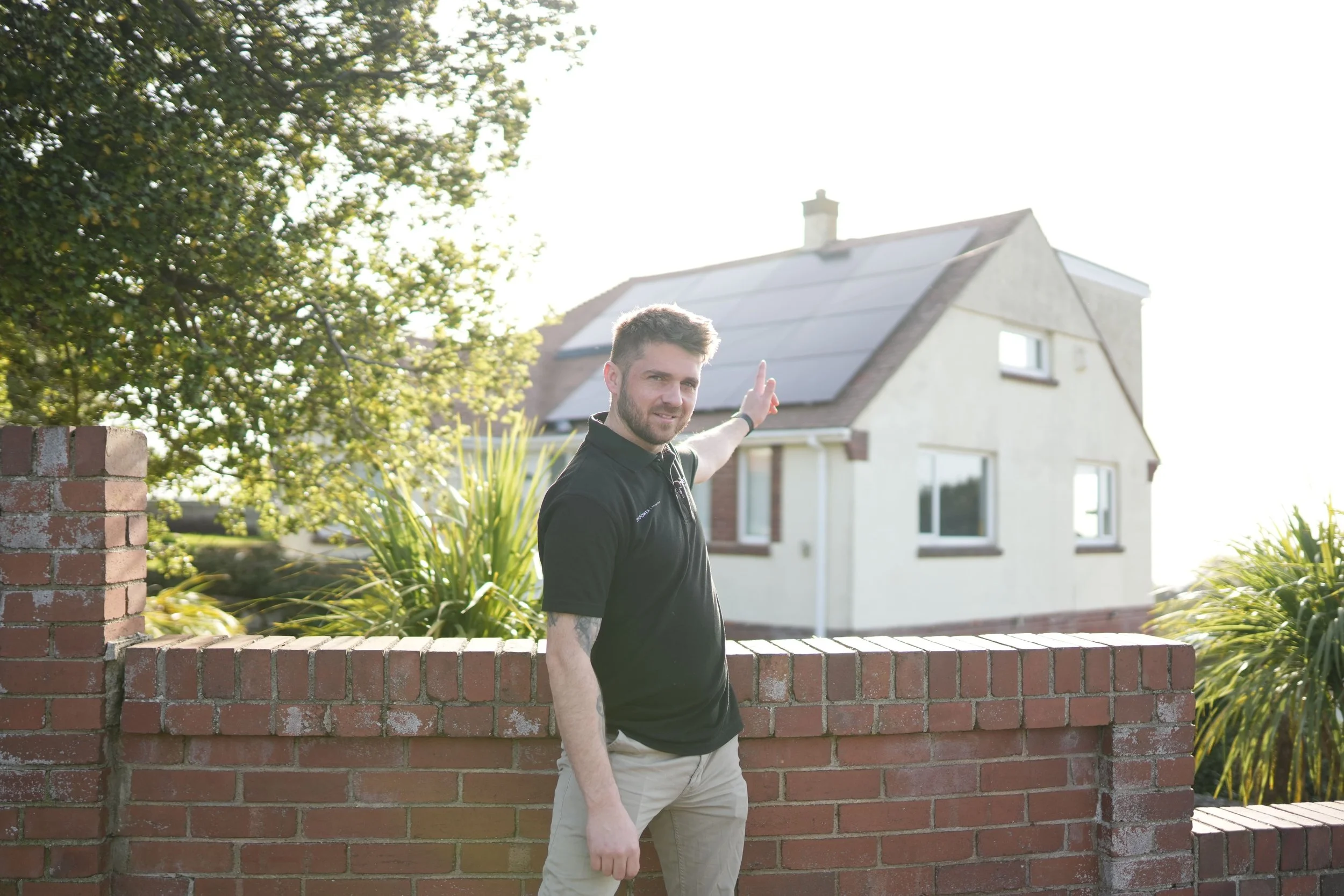 Dan Barnes of Simple Solar beside a rooftop solar panel installation in Plymouth