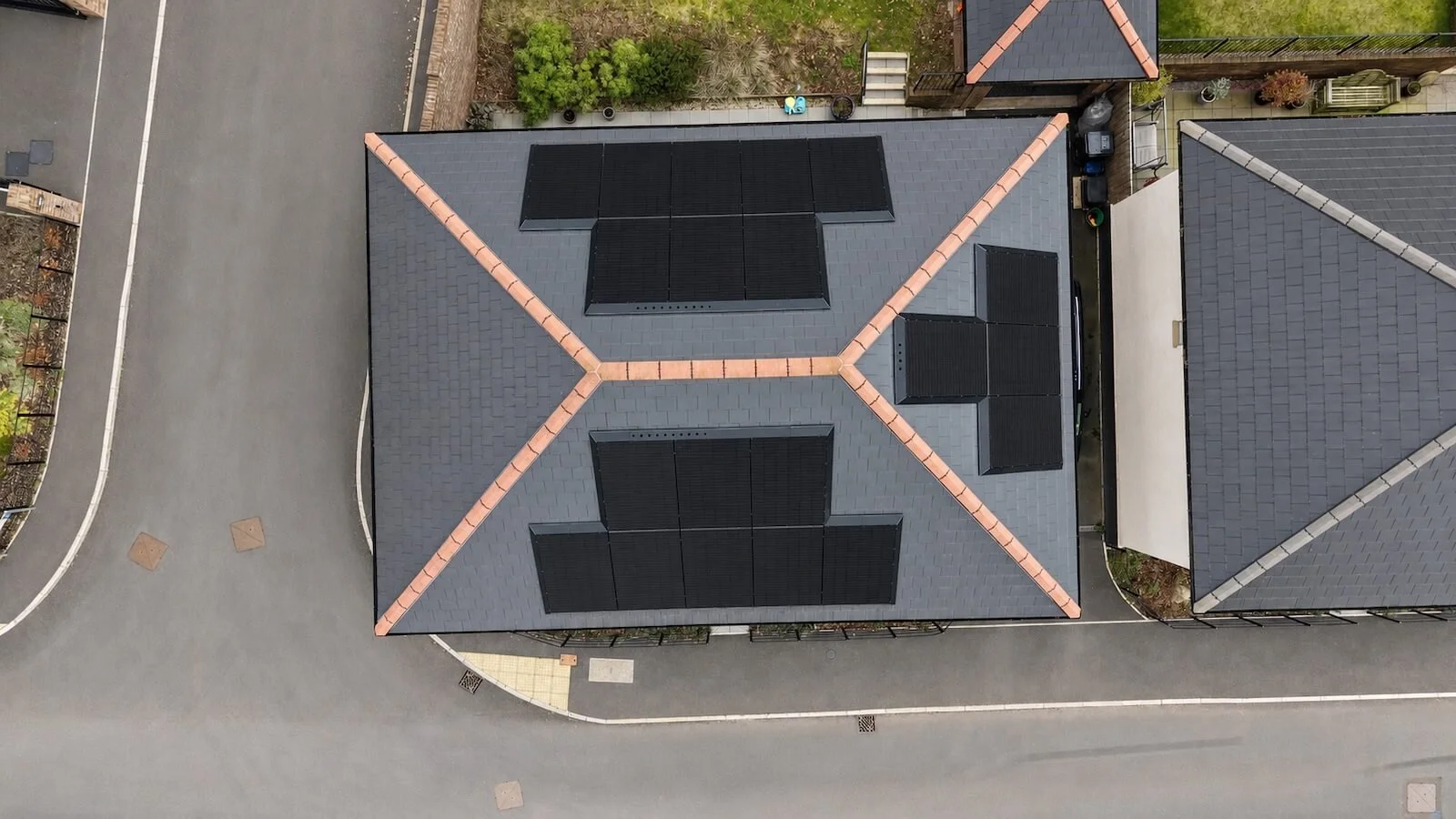 Aerial view of solar panel arrays installed across multiple roof slopes of a detached home in Tavistock