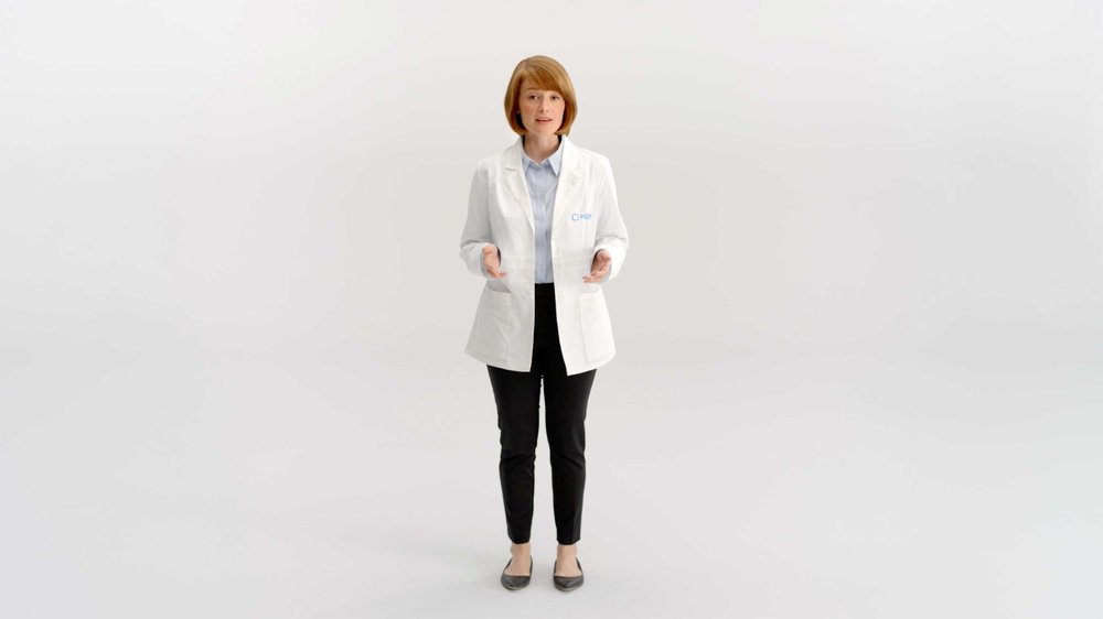 A woman in a white lab coat stands on a white studio background in PillPack's website explainer video