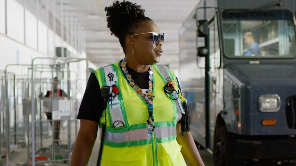 Amazon fulfillment center employee Kisha Best in North Carolina wearing safety vest for internal communications video.