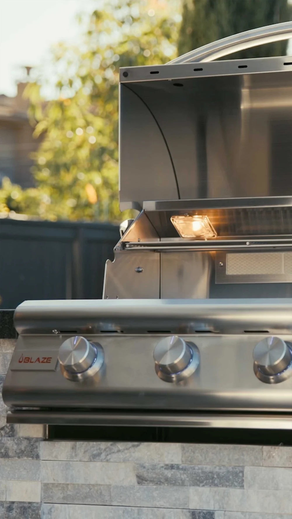 A gas grill with the lid open in a vertical video for social for BBQ Guys