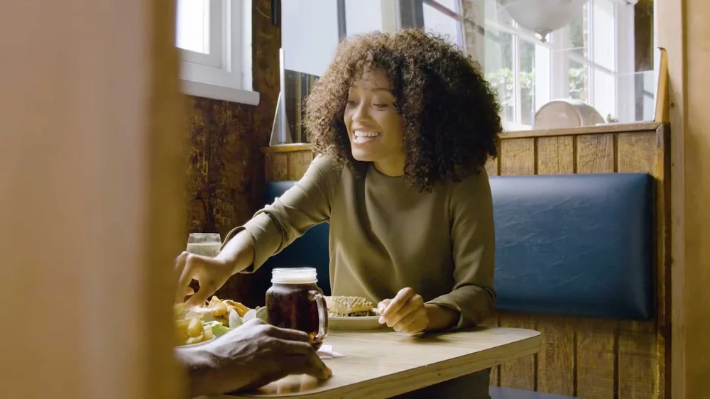 A woman eating lunch at a diner in a travel and tourism commercial video