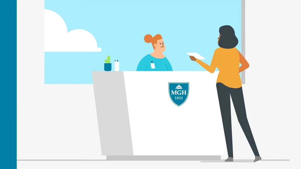 Animated hospital receptionist speaking with a patient at the Mass General Brigham front desk during a CT scan appointment.