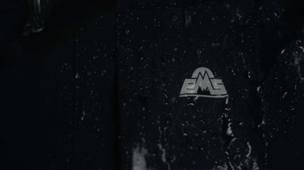 Close-up product video showcasing waterproof Nor’easter 3-in-1 jacket fabric in rainy conditions